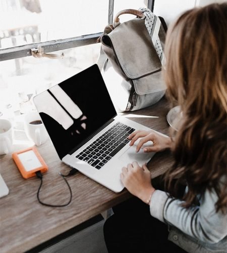 wearing-grey-long-sleeved-shirt-using-macbook-pro-min